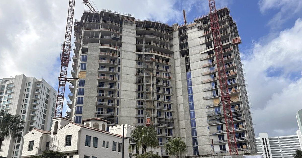 High-rise condominium building under construction with cranes and scaffolding