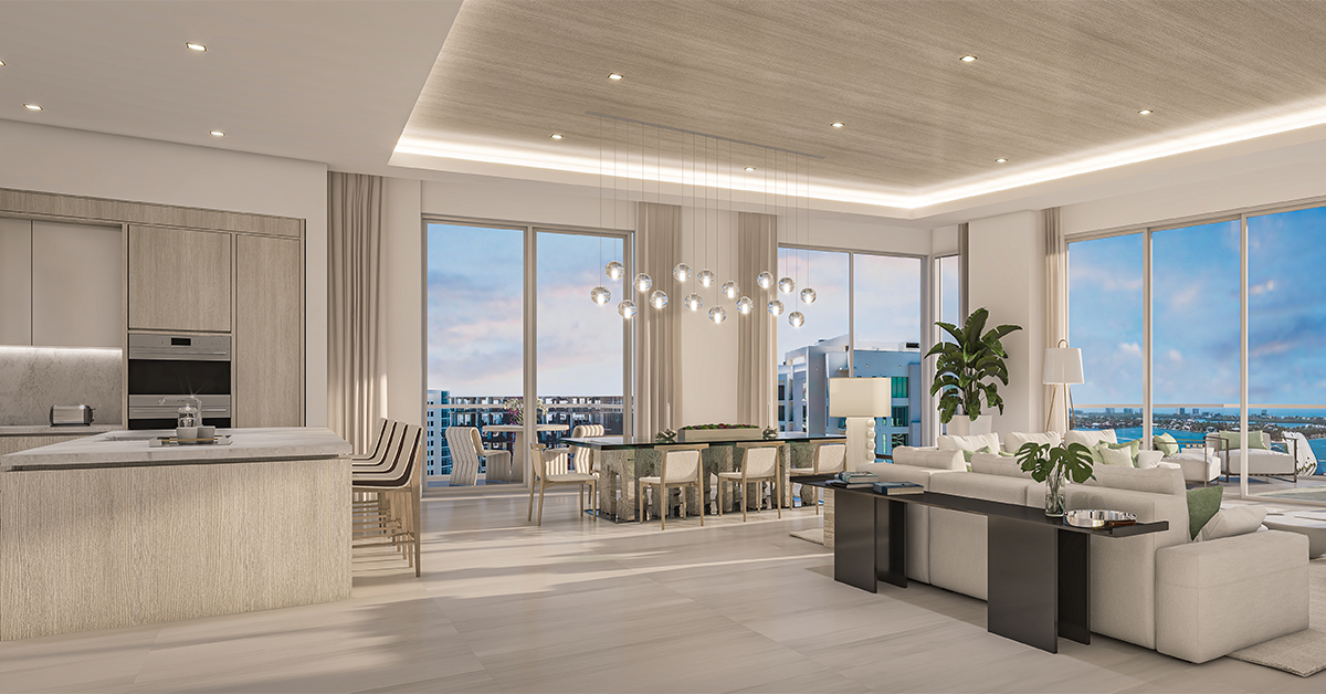 Luxury penthouse interior with open kitchen and living area overlooking Sarasota Bay through floor-to-ceiling windows.