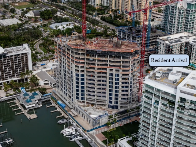 North elevation of waterfront high-rise under construction with cranes and marina.