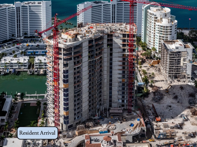 South elevation of waterfront tower under construction with crane and docks.