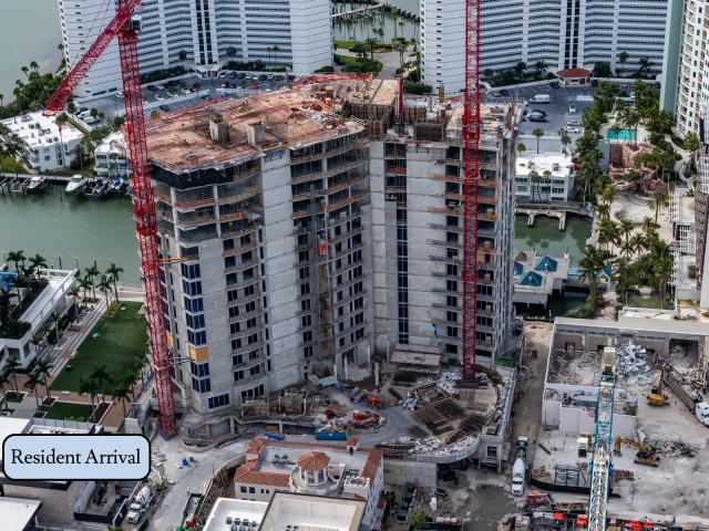 South side of residential tower under construction with cranes and staging area.