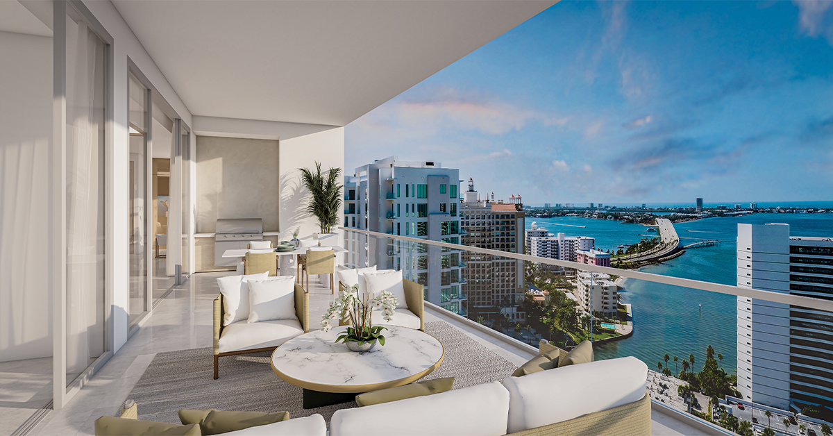 Private terrace with lounge chairs and marble table overlooking Sarasota Bay at sunset.