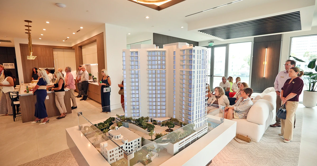 Guests viewing residential tower model at Sarasota Bay presentation gallery.
