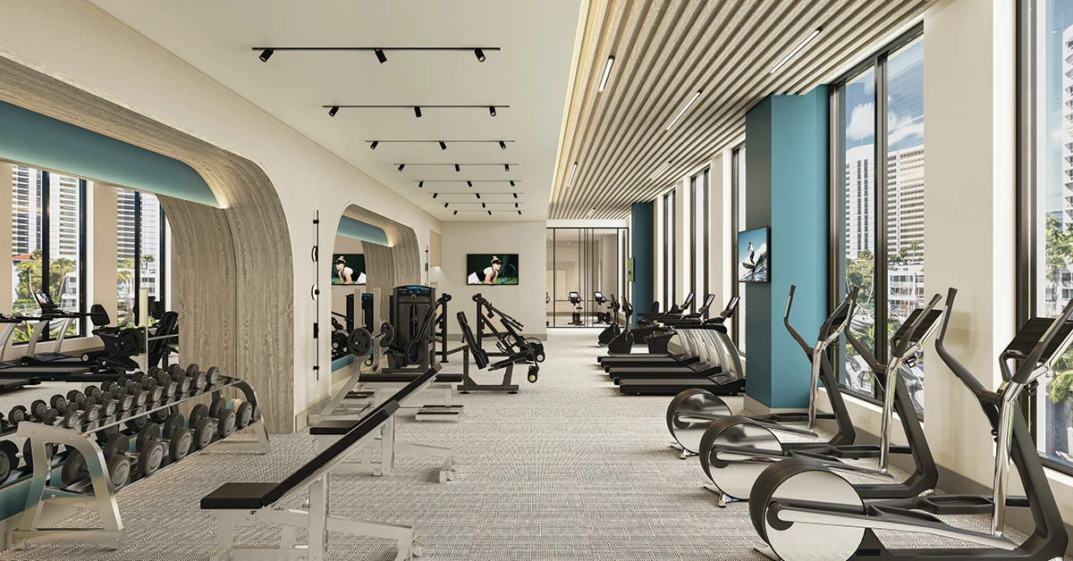Modern fitness center with cardio machines, weights, benches, windows, and city views.